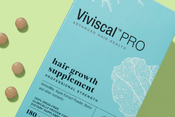 Viviscal PRO hair growth supplement box with tablets on green background